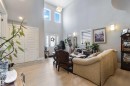 The property features high ceilings, light-colored flooring, and large windows providing natural light - 4 Lakeshore Cove, Beaumont, AB 