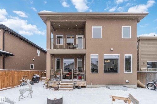 The property features a two-story exterior with a light brown stucco finish and a flat roofline - 4 Lakeshore Cove, Beaumont, AB 