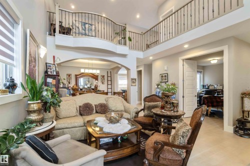 Spacious living area featuring high ceilings, recessed lighting, and an open balcony overlooking the space - 4 Lakeshore Cove, Beaumont, AB 