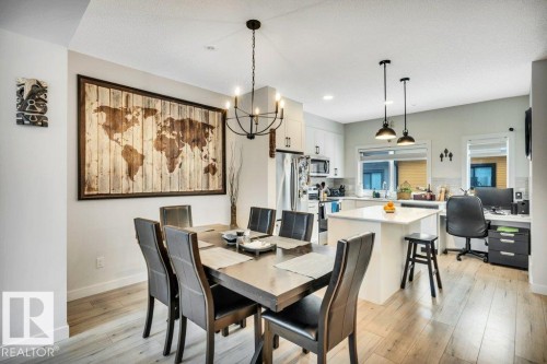 Open concept dining area with light hardwood floors and a modern light fixture - 99 1010 Rabbit Hill Road, Edmonton, AB - Indoor Photo Showing Dining Room