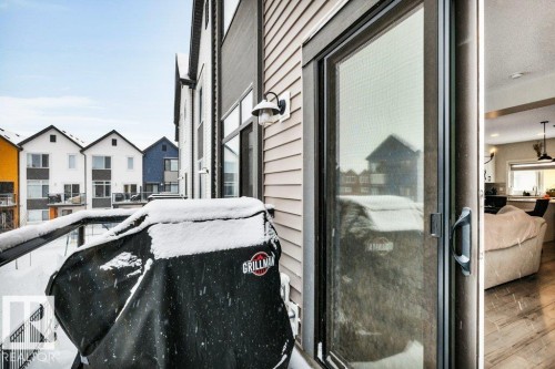 The property features a balcony with metal railings and a glass panel, offering views of the surrounding neighborhood - 99 1010 Rabbit Hill Road, Edmonton, AB - 