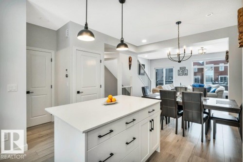 The property features an open-concept living area with a kitchen island, dining space, and living room - 99 1010 Rabbit Hill Road, Edmonton, AB - Indoor