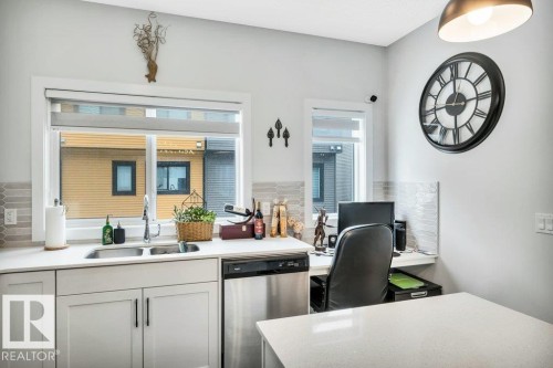 The kitchen features a double basin stainless steel sink, a stainless steel dishwasher, and white cabinetry - 99 1010 Rabbit Hill Road, Edmonton, AB - Indoor