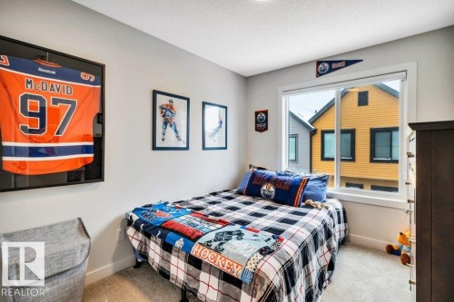 This room features neutral-toned walls, a window providing natural light, and carpeted flooring - 99 1010 Rabbit Hill Road, Edmonton, AB - Indoor Photo Showing Bedroom