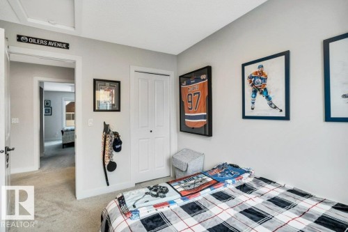 Bedroom featuring neutral-toned walls, a closet with bi-fold doors, and carpeting - 99 1010 Rabbit Hill Road, Edmonton, AB - Indoor