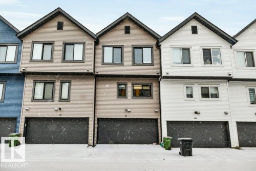 The property features a multi-story exterior with horizontal siding, a peaked roofline, and an integrated garage - 99 1010 Rabbit Hill Road, Edmonton, AB - Outdoor With Facade
