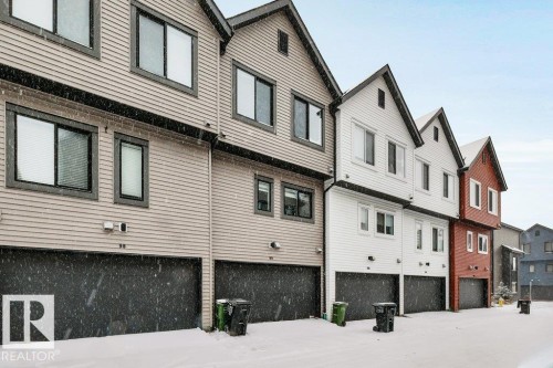 The property features an exterior with horizontal siding and black-framed windows, complemented by a black garage door - 99 1010 Rabbit Hill Road, Edmonton, AB - Outdoor