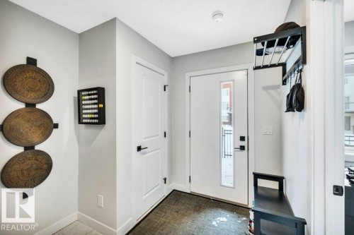 Inviting entryway featuring a white entry door with a glass insert, light gray walls, and light-colored flooring - 99 1010 Rabbit Hill Road, Edmonton, AB - Indoor Photo Showing Other Room