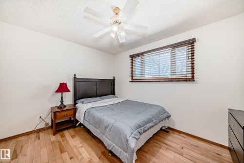 The room features light hardwood flooring, white walls, and a window with wooden blinds - 4237 116 Avenue, Edmonton, AB - Indoor Photo Showing Bedroom