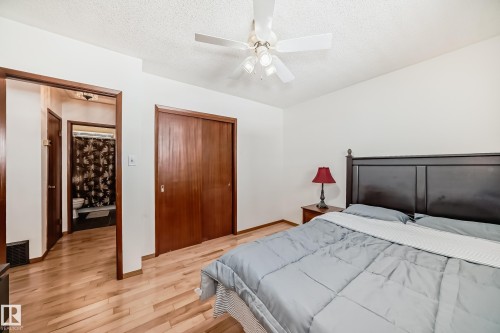 The property features light wood flooring, a ceiling fan with integrated lighting, and a closet with wood sliding doors - 4237 116 Avenue, Edmonton, AB - Indoor Photo Showing Bedroom