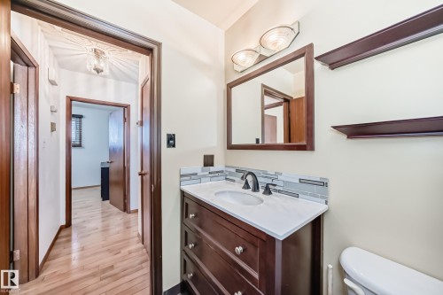 The bathroom features a dark wood vanity with a white countertop and an undermount sink - 4237 116 Avenue, Edmonton, AB - Indoor Photo Showing Bathroom