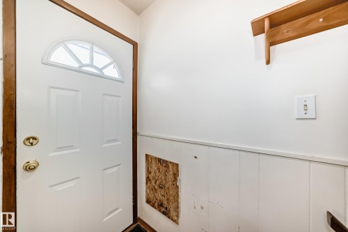 Entryway featuring a white door with an arched window, a wooden doorframe, and white wainscoting - 4237 116 Avenue, Edmonton, AB - Indoor Photo Showing Other Room
