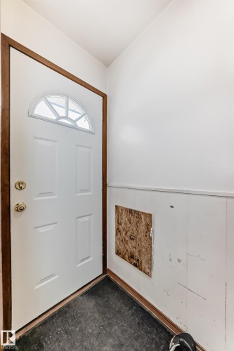 Entryway featuring a white door with an arched window, dark flooring, and white paneled walls - 4237 116 Avenue, Edmonton, AB - Indoor Photo Showing Other Room