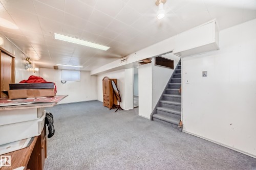 Spacious open area with carpeted flooring and exposed overhead beams - 4237 116 Avenue, Edmonton, AB - Indoor