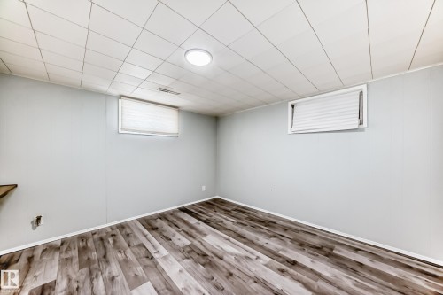 This versatile room features light-colored walls and wood-look flooring, creating a bright and adaptable space - 4237 116 Avenue, Edmonton, AB - Indoor