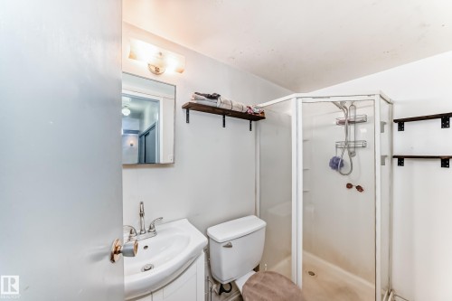 Bathroom featuring a shower with a clear glass enclosure, a toilet, and a vanity with a sink and mirror - 4237 116 Avenue, Edmonton, AB - Indoor Photo Showing Bathroom