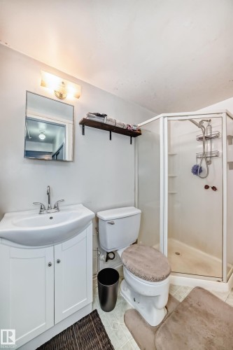 A bathroom featuring a white vanity with a sink and chrome faucet, a toilet, and a glass-enclosed shower - 4237 116 Avenue, Edmonton, AB - Indoor Photo Showing Bathroom