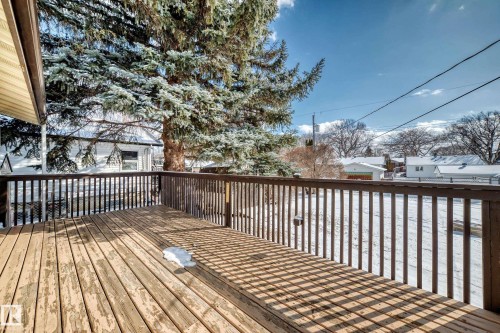 The property features an outdoor wooden deck with a railing, offering views of the surrounding outdoor area - 4237 116 Avenue, Edmonton, AB - Outdoor With Deck Patio Veranda