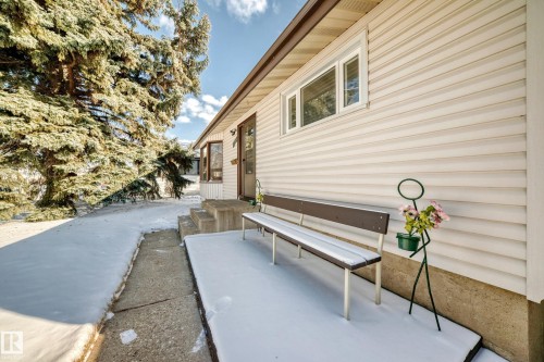 The property features a light-colored exterior siding, a front entry with a dark-colored door, and a concrete pathway leading to the entrance - 4237 116 Avenue, Edmonton, AB - Outdoor With Exterior