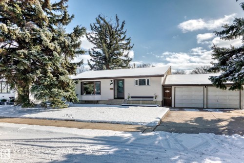 The property features a white exterior with a dark roof and a two-car garage - 4237 116 Avenue, Edmonton, AB - Outdoor