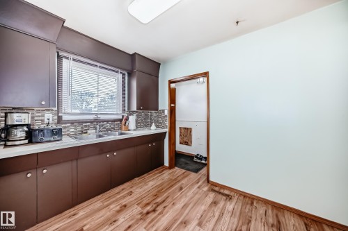 The kitchen features rich brown cabinetry, a white countertop, and a double basin sink - 4237 116 Avenue, Edmonton, AB - Indoor