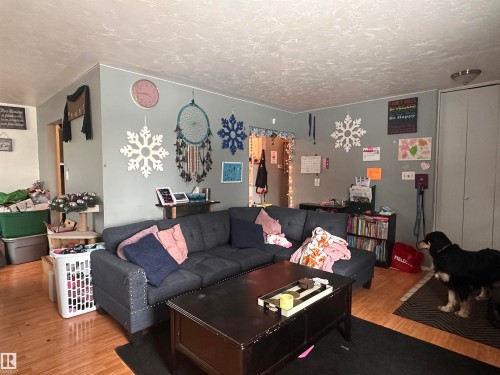 Living room featuring hardwood flooring, light gray walls, and a recessed ceiling light fixture - 9724 102 Avenue, Westlock, AB - Indoor Photo Showing Living Room