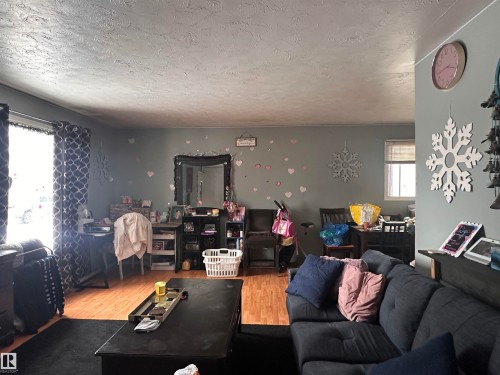This living space features wood flooring and a window with blinds, allowing for natural light - 9724 102 Avenue, Westlock, AB - Indoor Photo Showing Living Room