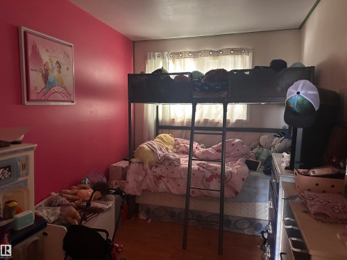 The room features a window with curtains and wood flooring - 9724 102 Avenue, Westlock, AB - Indoor