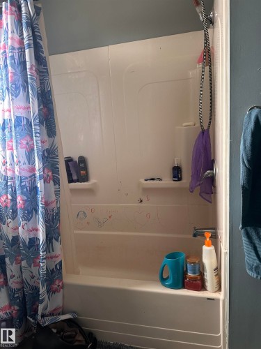 Bathroom featuring a white bathtub and shower combination unit - 9724 102 Avenue, Westlock, AB - Indoor