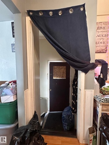 The property features a dark-colored door with a window, set within a doorway - 9724 102 Avenue, Westlock, AB - Indoor Photo Showing Other Room