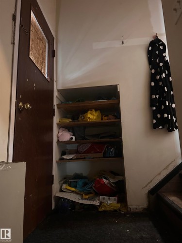 Entryway featuring a dark wood door with a glass panel, built-in shelving, and carpeted flooring - 9724 102 Avenue, Westlock, AB - Indoor