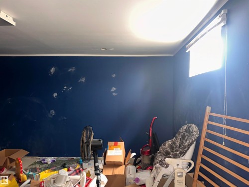 Room featuring a window with a roller blind and a ceiling with an exposed light fixture - 9724 102 Avenue, Westlock, AB - Indoor