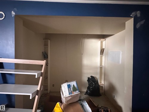 This room features built-in shelving and an open-concept design with a wide entry - 9724 102 Avenue, Westlock, AB - Indoor