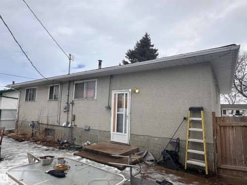 The property features a stucco exterior, a rear entry door, and a fenced yard - 9724 102 Avenue, Westlock, AB - Outdoor