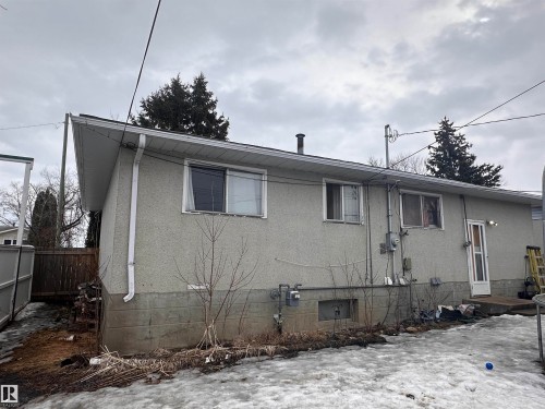 The property features a light-colored exterior with white trim and a white door, complemented by white downspouts and gutters - 9724 102 Avenue, Westlock, AB - Outdoor
