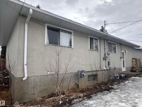 The property features a stucco exterior with a visible foundation - 9724 102 Avenue, Westlock, AB - Outdoor