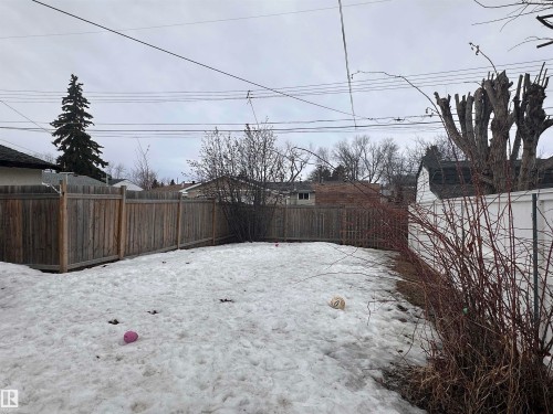The property features a fenced yard with a small shed and mature trees - 9724 102 Avenue, Westlock, AB - Outdoor