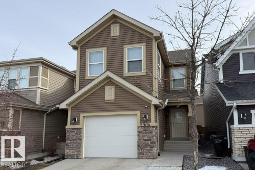 The property features a brown siding exterior with light trim, stone accents, and a white garage door - 5904 Anthony Crescent, Edmonton, AB - Outdoor With Facade
