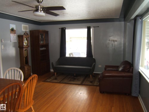 The property features wood flooring, a ceiling fan, and window coverings - 5023 50 Street, Two Hills, AB - Indoor