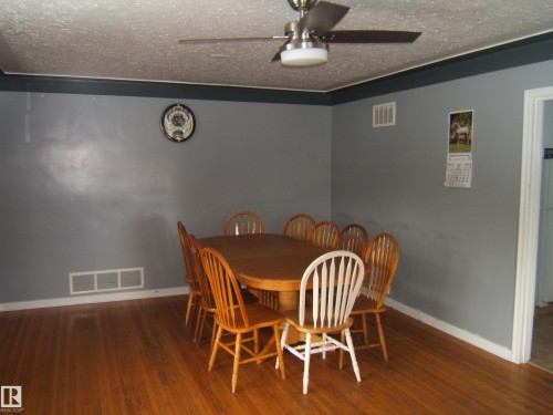 Dining area featuring hardwood floors, a ceiling fan, and painted walls with trim - 5023 50 Street, Two Hills, AB - Indoor Photo Showing Dining Room