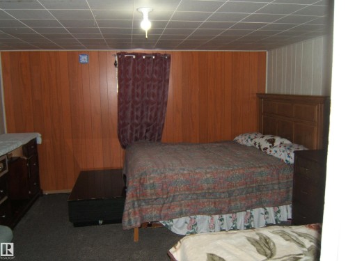This room features paneled walls and a drop ceiling - 5023 50 Street, Two Hills, AB - Indoor Photo Showing Bedroom