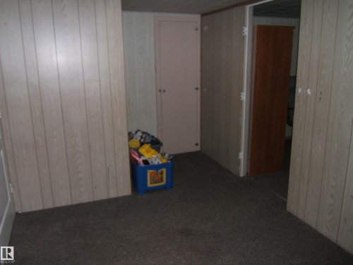 This room features carpeted flooring and walls with vertical paneling - 5023 50 Street, Two Hills, AB - Indoor Photo Showing Other Room