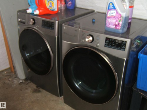 Laundry area featuring a pair of front-loading machines with digital displays - 5023 50 Street, Two Hills, AB - Indoor Photo Showing Laundry Room