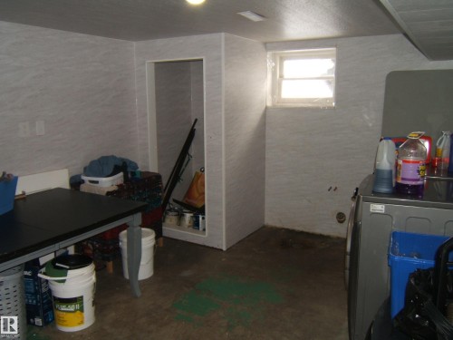 This utility space features a window, light-colored walls, and a concrete floor - 5023 50 Street, Two Hills, AB - Indoor