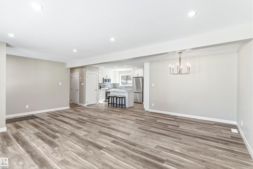 The property features an open-concept living area with wood-look flooring and recessed lighting - 11 Sonora Drive, St. Albert, AB - Indoor Photo Showing Other Room