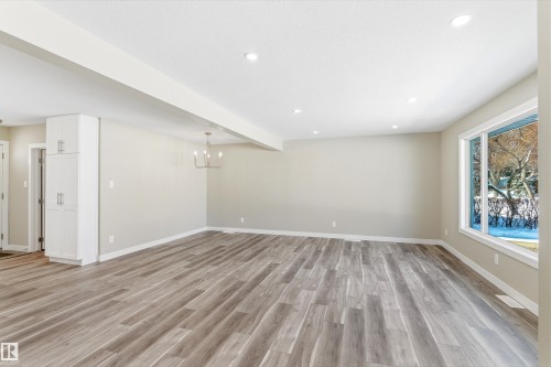Spacious living area featuring light-toned flooring, recessed lighting, and a large window providing views of the outdoors - 11 Sonora Drive, St. Albert, AB - Indoor Photo Showing Other Room