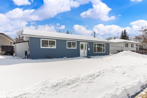 The property features blue horizontal siding, a white front door, and white window frames - 11 Sonora Drive, St. Albert, AB - Outdoor