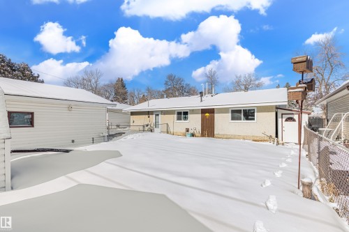 The property features a spacious rear yard with a snow-covered lawn and a detached garage - 11 Sonora Drive, St. Albert, AB - Outdoor