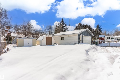 The property features a detached garage with a light grey siding and a separate shed with a gambrel roof and a brown door - 11 Sonora Drive, St. Albert, AB - Outdoor