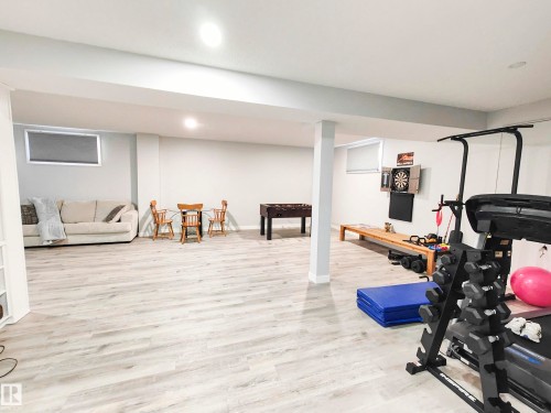 This expansive room features light-colored flooring and white walls, creating a bright and open atmosphere - 215 Peter Close Nw, Edmonton, AB - Indoor Photo Showing Gym Room